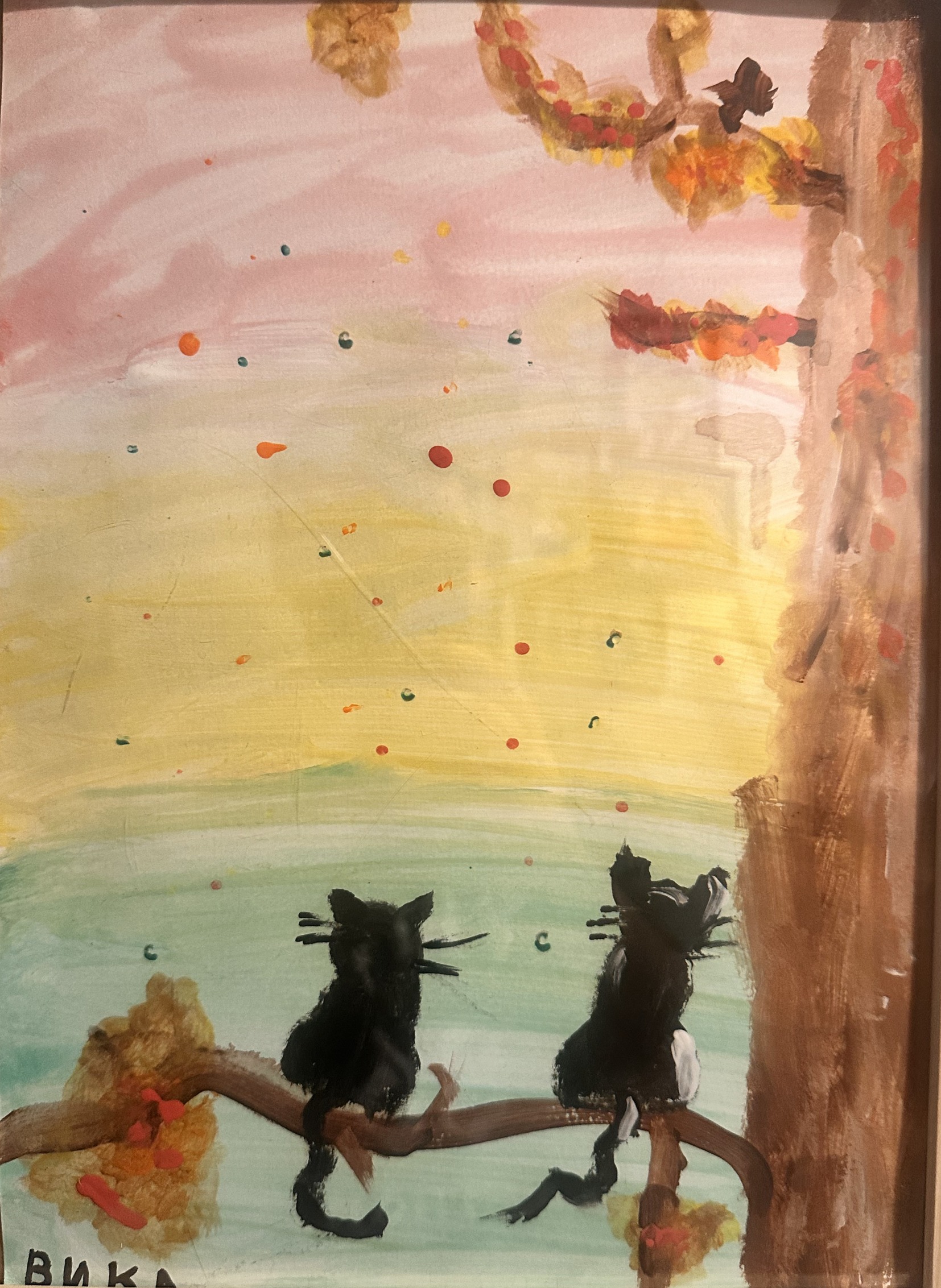 Child's watercolor painting of two black cats sitting on a tree branch under autumn leaves with a pink-and-teal sky